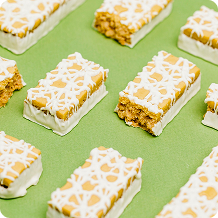 Bars of cereal and peanut butter mixture arranged on a green surface