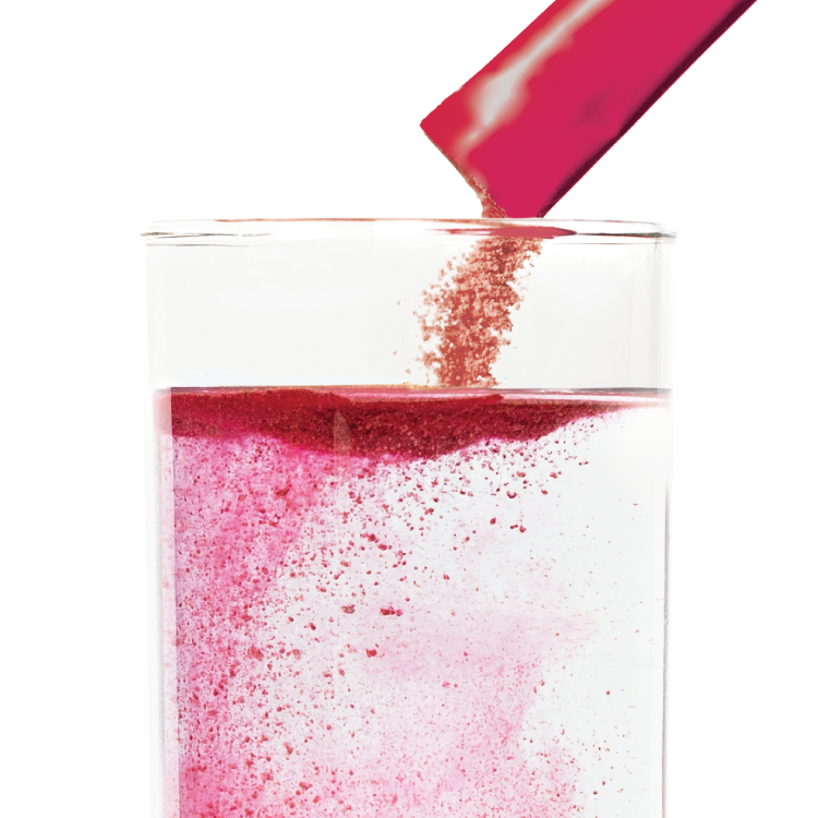 Berry packet being poured into glass of water