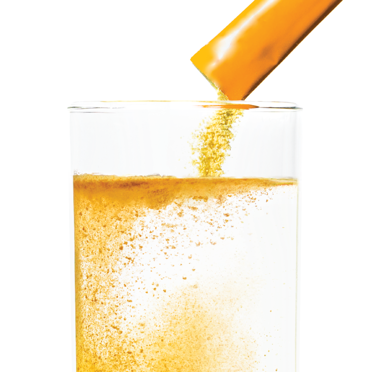 Orange packet being poured into glass of water.