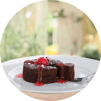 Double chocolate cake on a plate with cherry topping