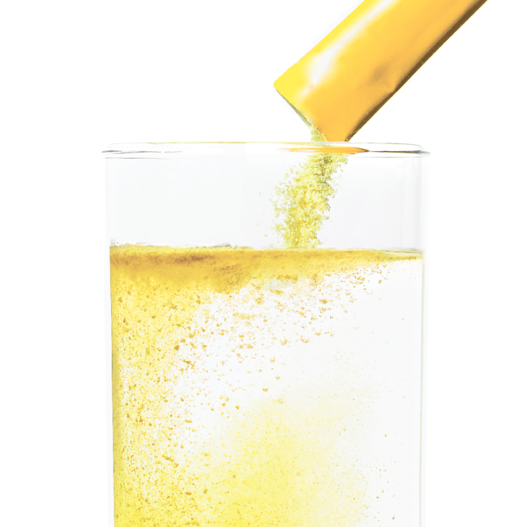 Lemonade packet being poured into glass of water.